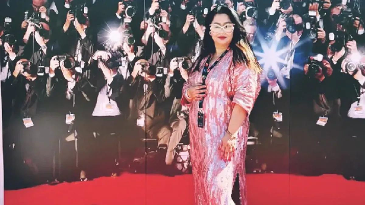 Faridi Eram standing at the Cannes Film Festival, smiling, representing India.
