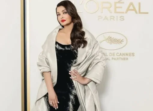 Aishwarya Rai Bachchan smiling brightly on the Cannes Film Festival red carpet.