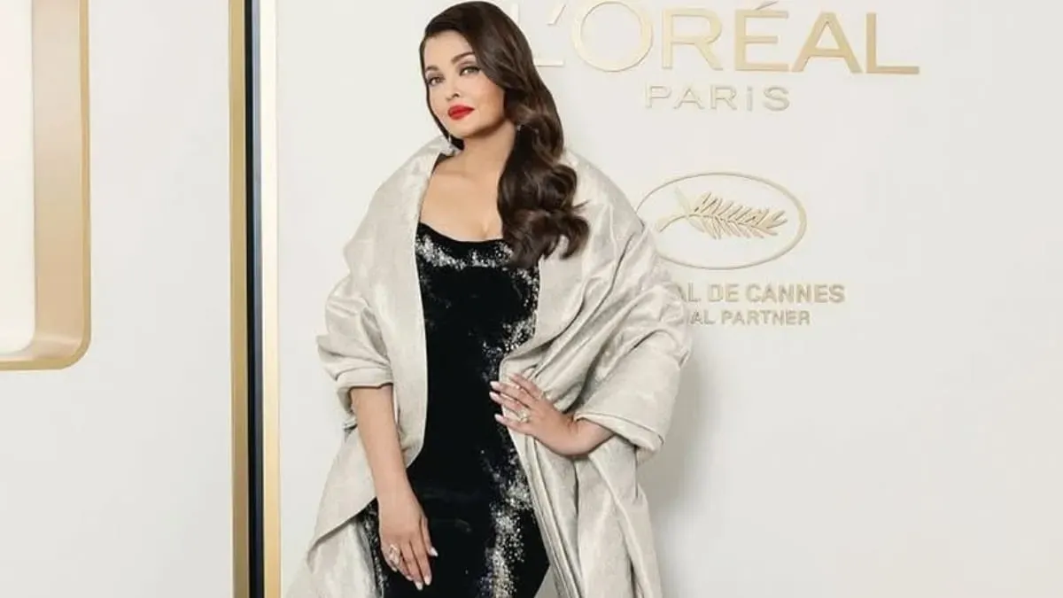 Aishwarya Rai Bachchan smiling brightly on the Cannes Film Festival red carpet.