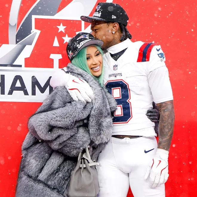 Cardi B and Stefon Diggs smiling and showing affection at a Mother's Day event.
