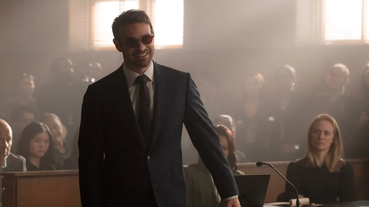Charlie Cox as Daredevil in a shadowy, action-filled pose.