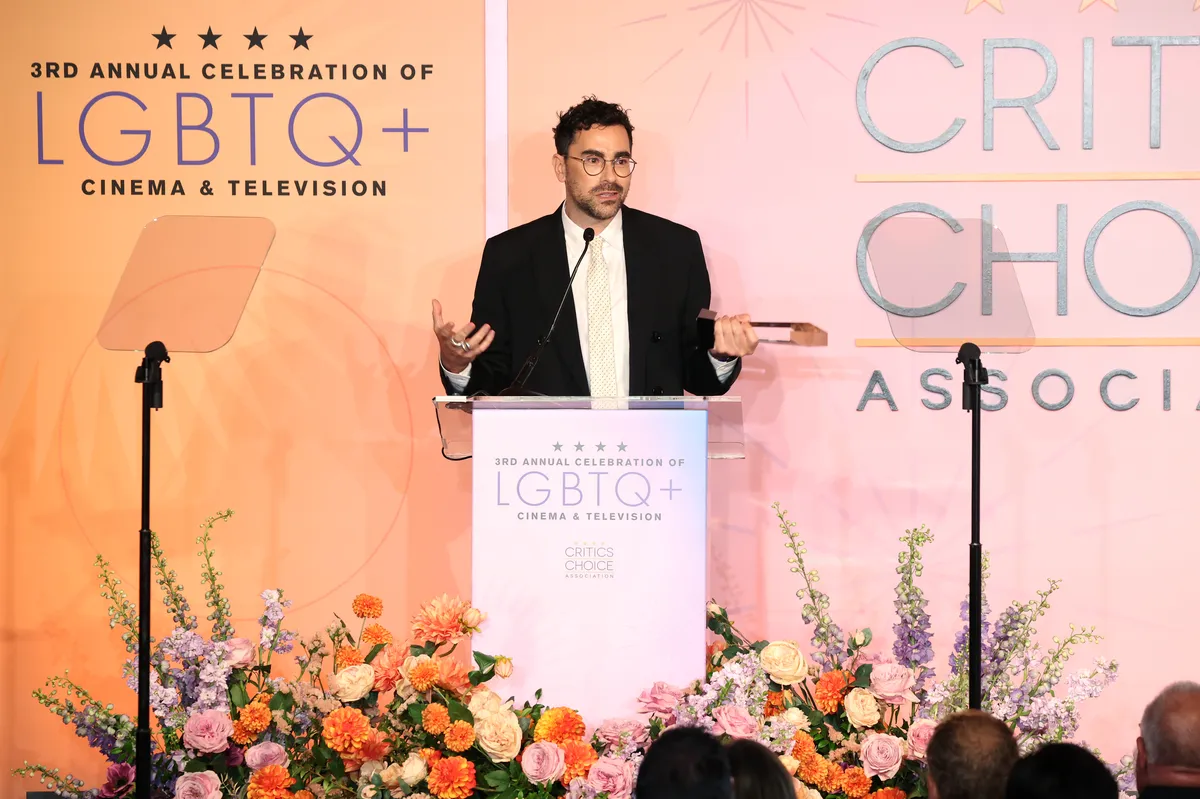 Dan Levy accepting an award on stage.