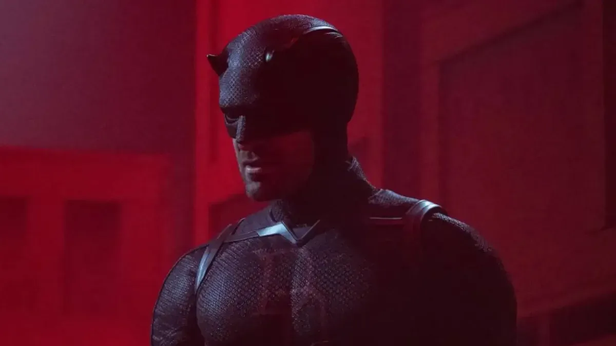 Daredevil in his red suit, leaping across a dark, rainy city skyline.
