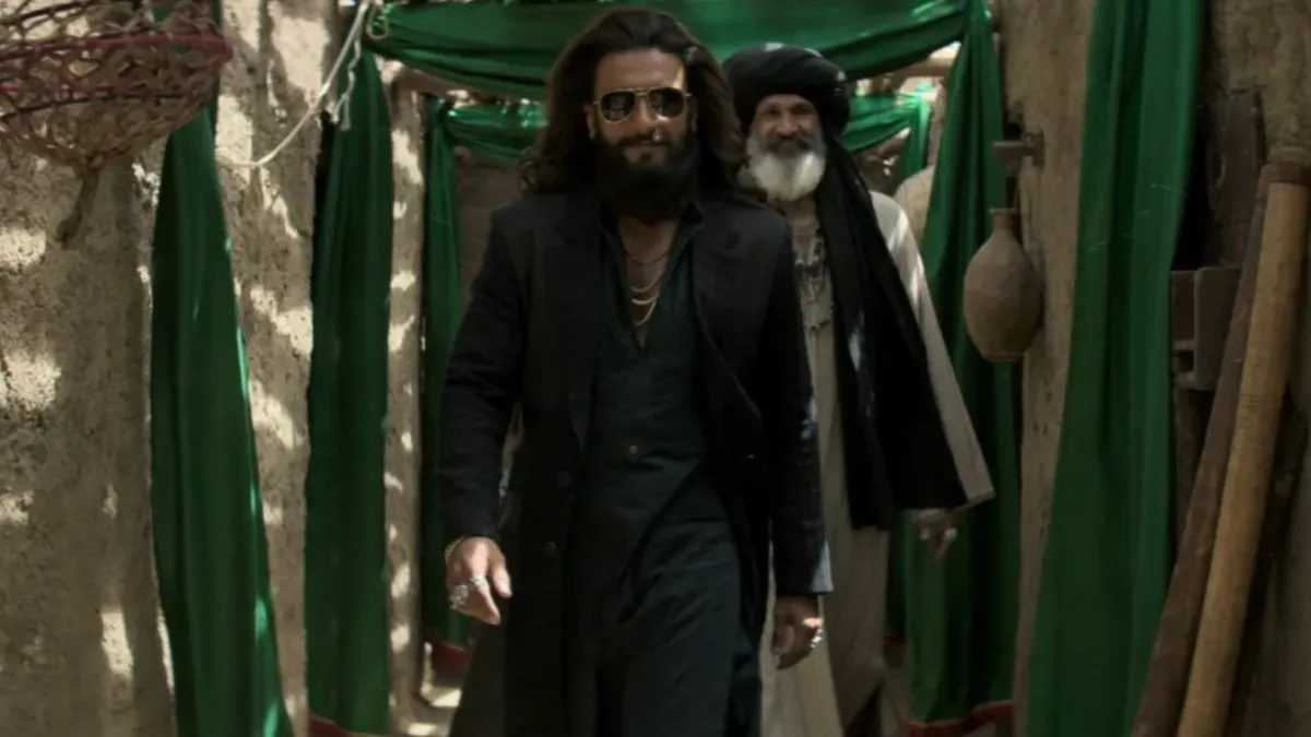 Ranveer Singh and Sara Arjun looking thoughtful in a scene from 'Dhurandhar 2' against a muted backdrop.