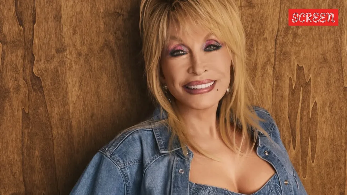 Dolly Parton smiling and wearing a sparkly outfit.