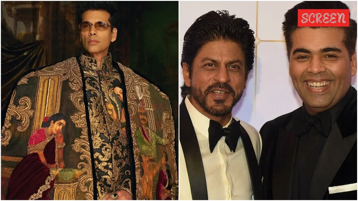 Karan Johar posing on the red carpet with a dramatic fashion look