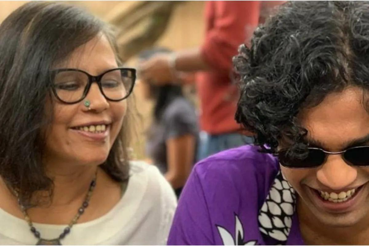 Sutapa Sikdar smiling warmly, with a subtle glow around her, conveying a mother's love.