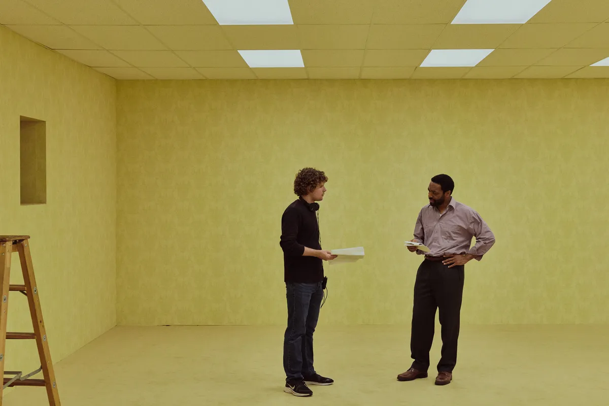Movie poster for 'Backrooms' with a character looking into a mysterious, empty space.