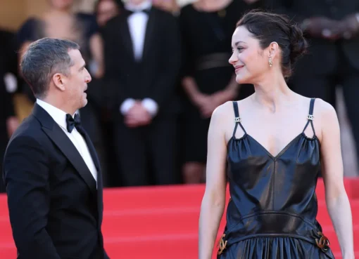 Guillaume Canet and Marion Cotillard smiling and posing together at a press conference.