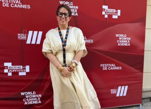 Guneet Monga Kapoor smiling brightly, exuding confidence, possibly at the Cannes Film Festival.