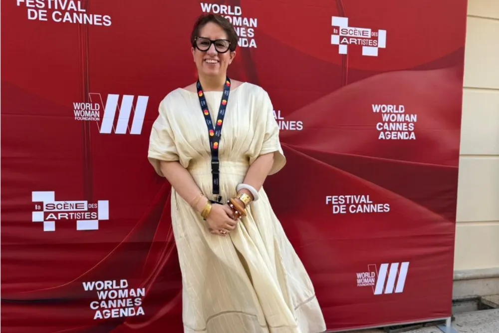 Guneet Monga Kapoor smiling brightly, exuding confidence, possibly at the Cannes Film Festival.