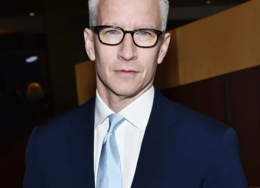 Anderson Cooper sitting at a news desk looking professional.