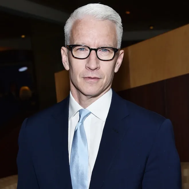Anderson Cooper sitting at a news desk looking professional.