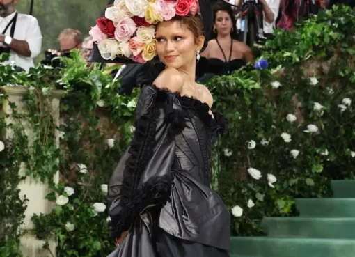 Zendaya striking a pose on the red carpet at the Met Gala in a stunning, dramatic gown.