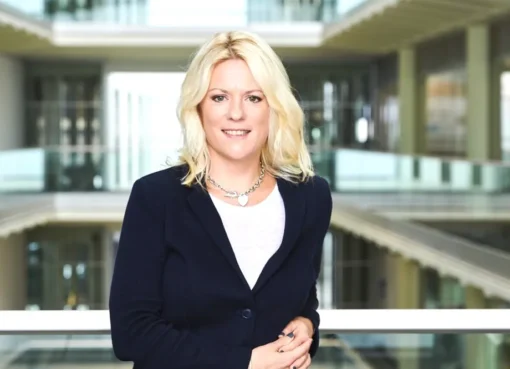 Photo of a confident woman, Rachel Corp, in a professional setting, looking surprised.
