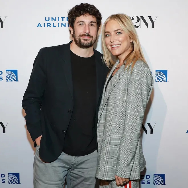 Photo of actors Jason Biggs and Jenny Mollen smiling together.