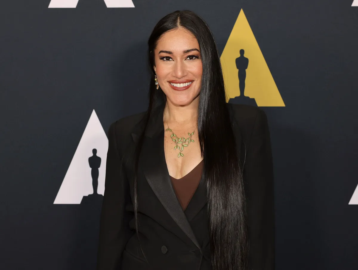 Actress Q'orianka Kilcher, with a backdrop of 'Avatar' and Disney imagery.