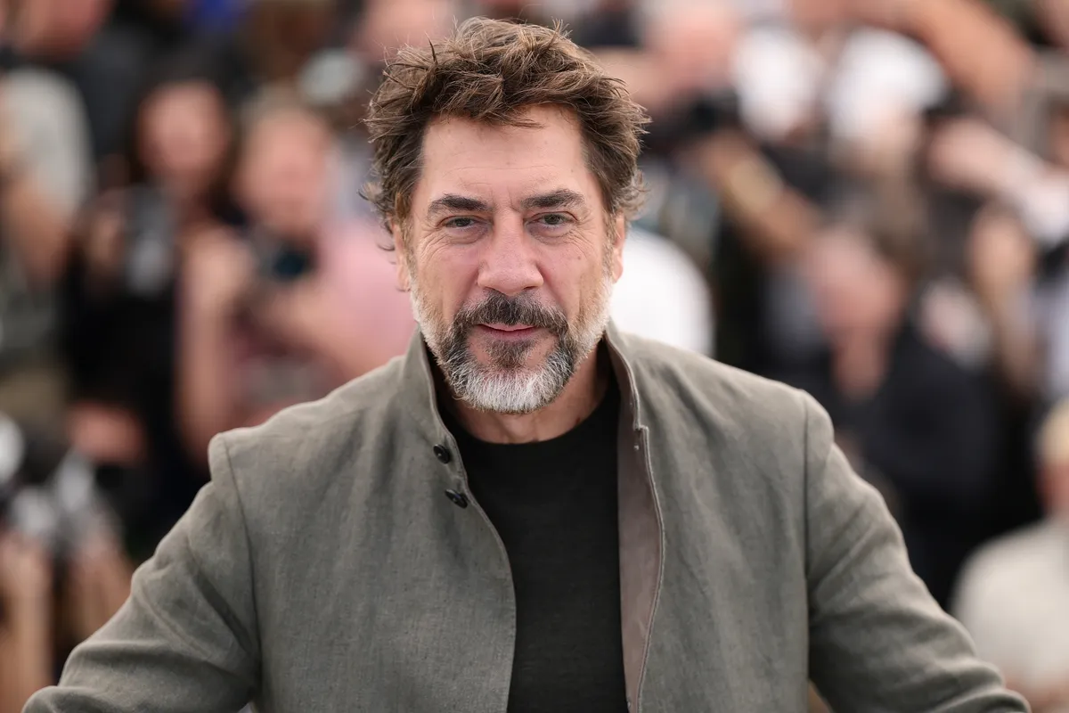 Javier Bardem speaking intently at a press conference in Cannes.