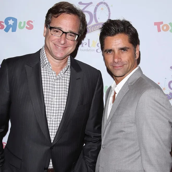 John Stamos and Bob Saget smiling in a photograph.