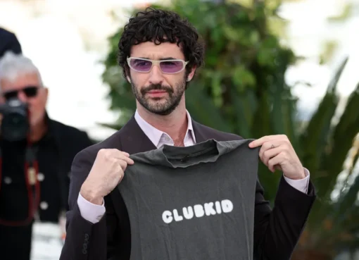 Jordan Firstman smiling on the red carpet at the Cannes Film Festival, celebrating the success of his film 'Club Kid'.