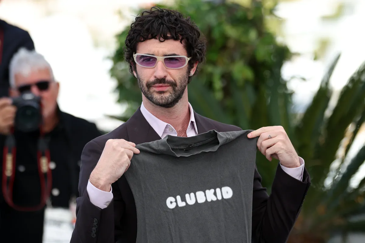 Jordan Firstman smiling on the red carpet at the Cannes Film Festival, celebrating the success of his film 'Club Kid'.
