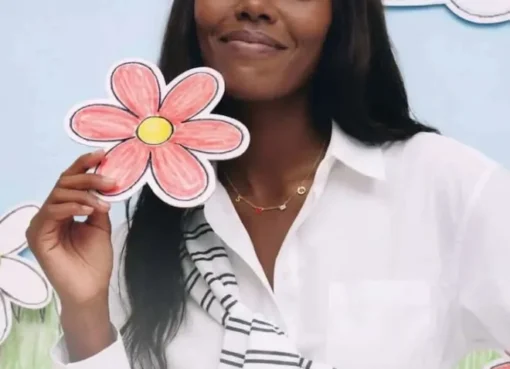 A smiling mother opening a small gift box with a happy expression on Mother's Day.