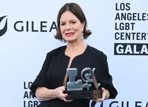 Marcia Gay Harden speaking at a colorful gala event