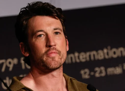 Miles Teller looking serious in a suit.