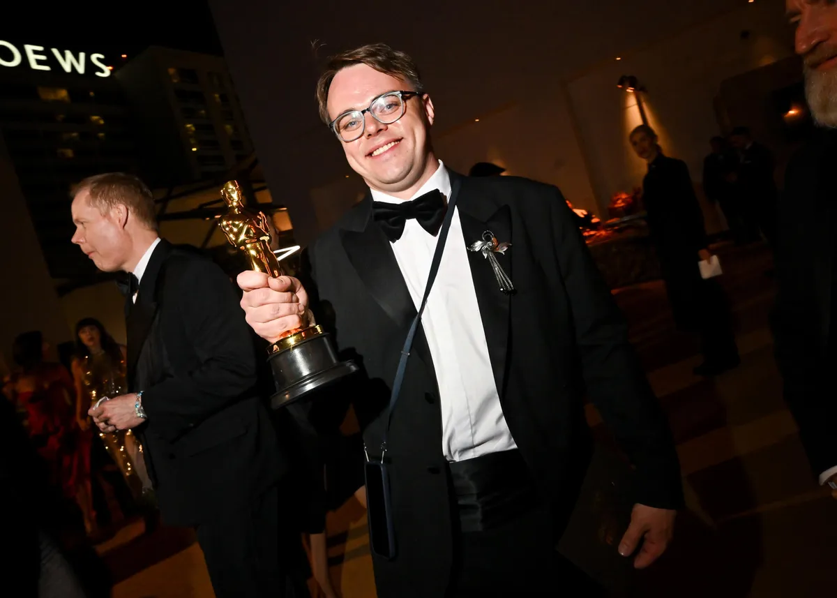 A golden Oscar statuette gleaming against a dark background.