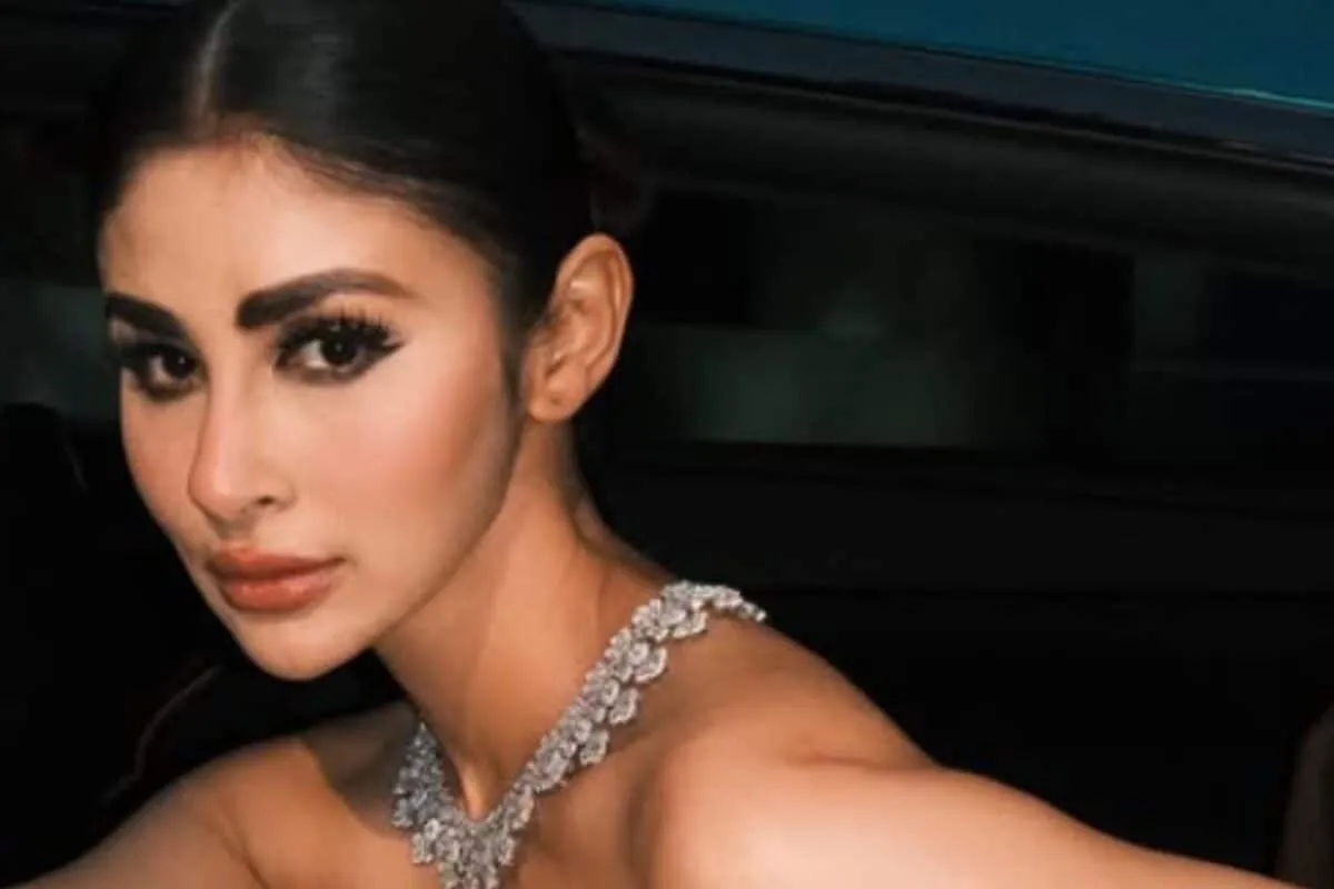 Mouni Roy wearing a crystal-patterned off-shoulder gown inside a luxury car at Cannes.