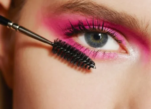 A colorful flat lay of various makeup, skincare, and haircare products like serums, lipsticks, and brushes, with a 'Sale' tag visible.