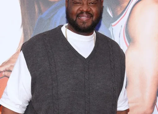 Grizz Chapman smiling slightly, possibly in character as a bodyguard.