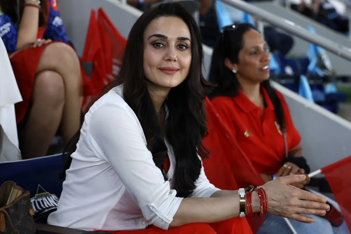Preity Zinta smiling at a cricket match.