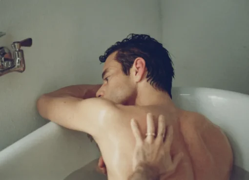 Rami Malek in a movie still, looking thoughtful and intense.