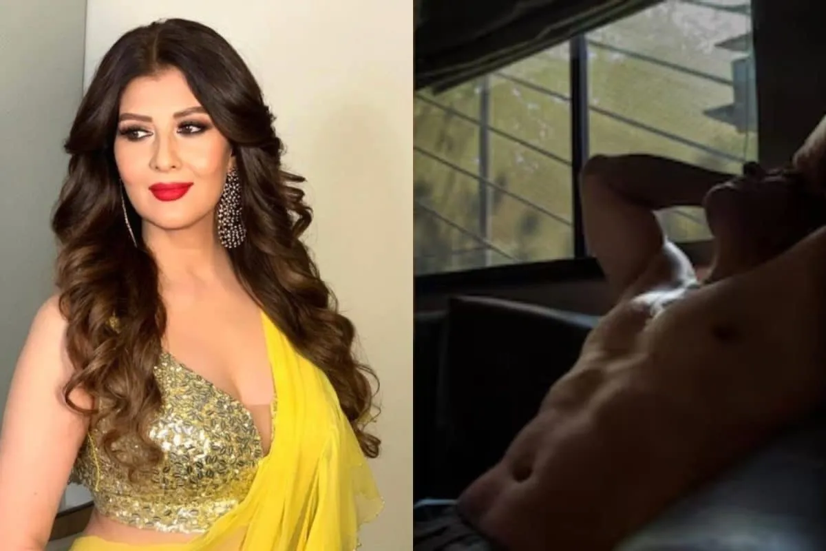 Salman Khan posing shirtless, looking out a window.