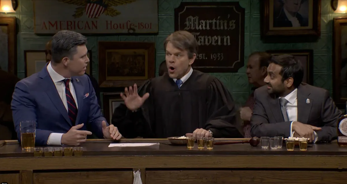 Matt Damon dressed as Brett Kavanaugh, Colin Jost as Pete Hegseth, and Aziz Ansari as Kash Patel in a bar setting.