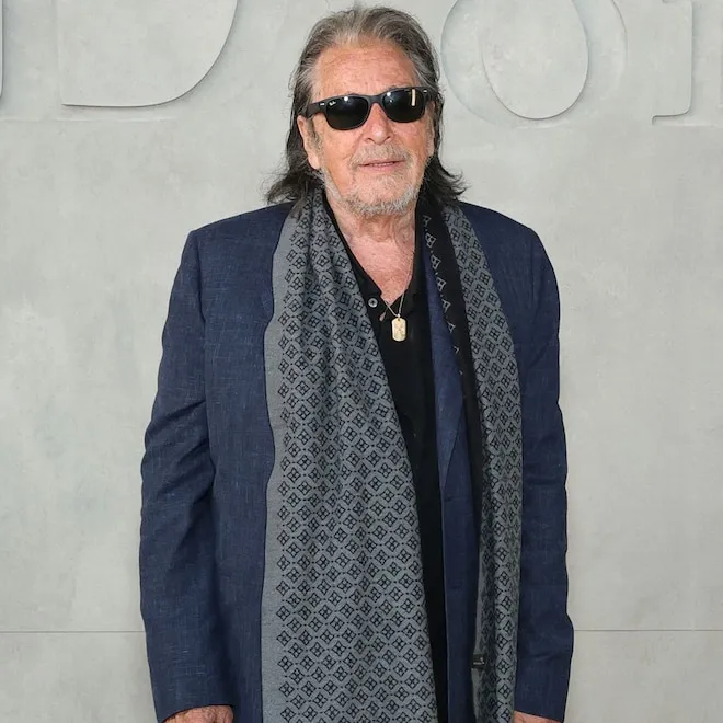 Al Pacino and Noor Alfallah posing for cameras at the Dior fashion show.