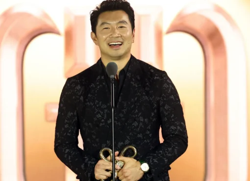 Simu Liu accepting an award on stage.