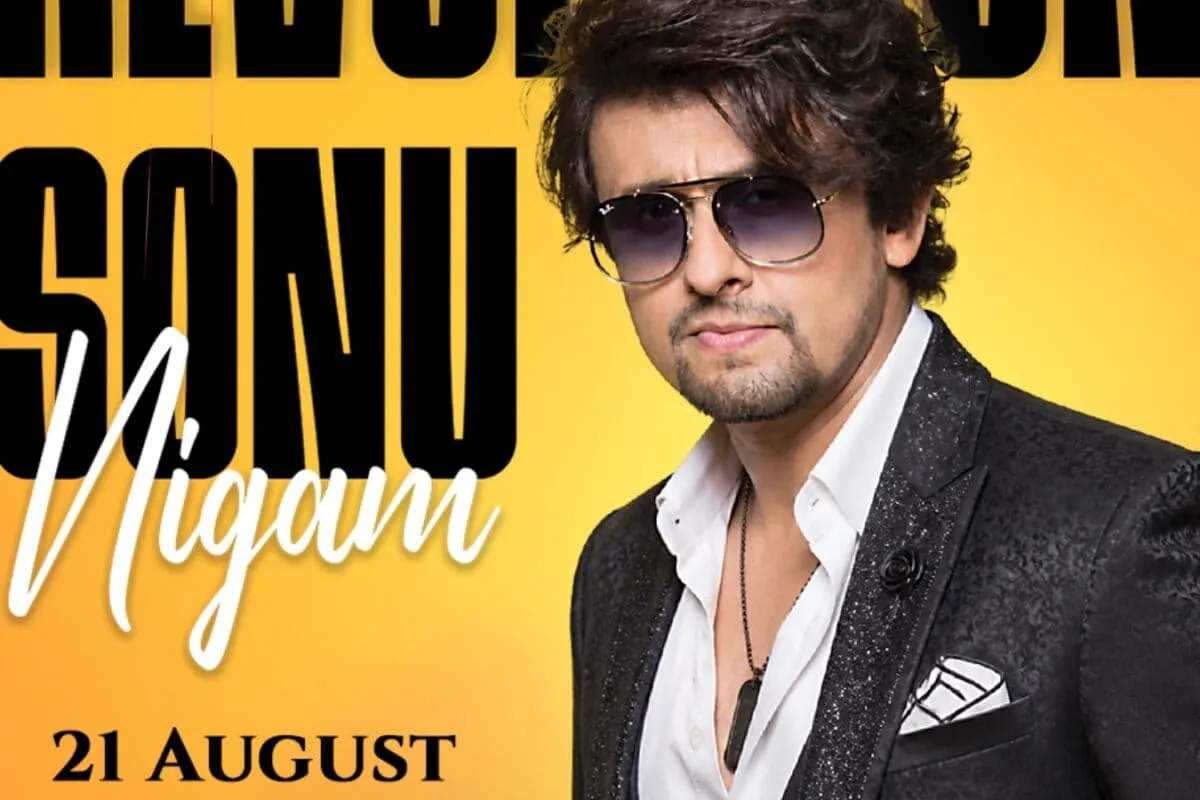 Sonu Nigam performing on stage with a colorful background.