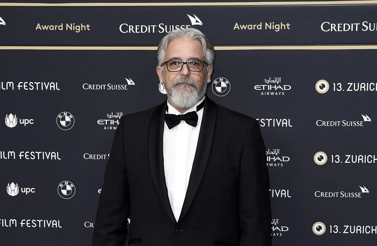 Filmmaker Constantin Popescu standing and looking thoughtful.