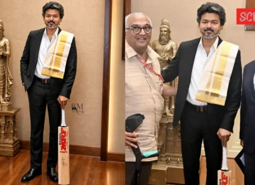 Tamil Nadu CM holding a red and gold cricket bat signed by Virat Kohli.