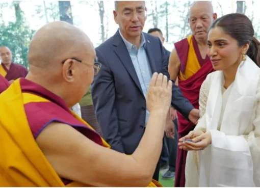 Bhumi Pednekar respectfully bows to The Dalai Lama, who is smiling warmly in a serene setting.