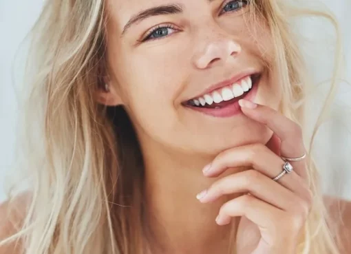 A close-up of a person smiling brightly, showing off perfectly white and healthy teeth.