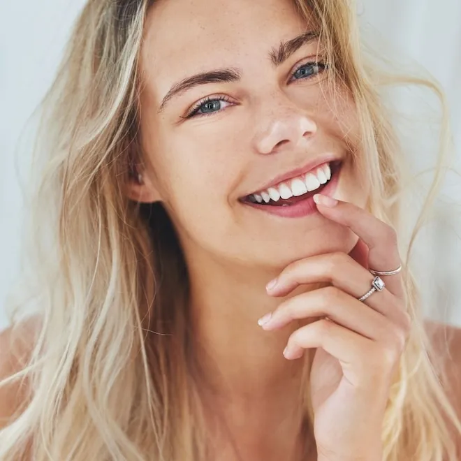 A close-up of a person smiling brightly, showing off perfectly white and healthy teeth.