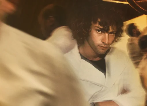 Dominic Sessa portrays a young Anthony Bourdain in a kitchen, looking determined.
