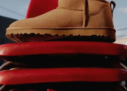 A close-up shot of several cozy UGG slippers and boots in various warm, earthy colors.