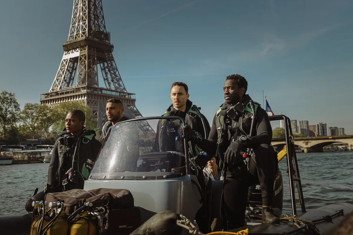 A promotional image showing a shark's fin emerging from city waters, with the Eiffel Tower in the background.