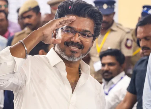 Actor Vijay waving to a large crowd of supporters