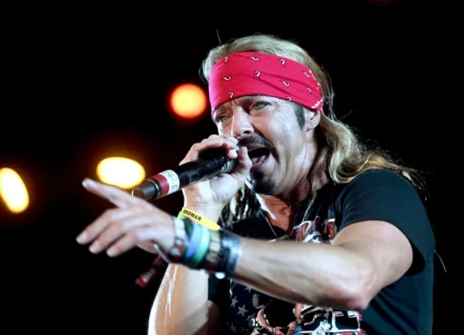 Bret Michaels smiling with a bandana and rock star hair.