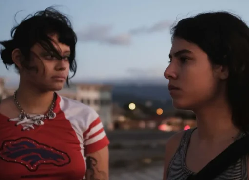 Two young women, sisters, sitting across from each other at a mall restaurant table.
